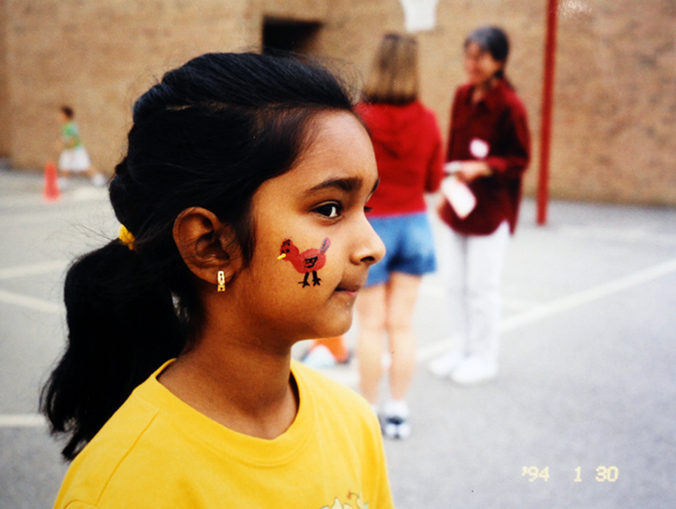 Close-up color photograph of a Cardinal Forest student taken in 1993. A cardinal has been painted on her face.